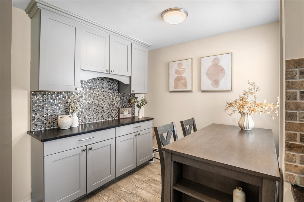5-7 Vernon Street, Unit 1 Haverhill, MA 01835 - Photo 5 of 22 a kitchen with white cabinets and table