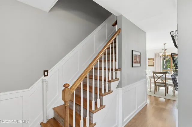 a view of staircase with lots of frames on wall and wooden floor