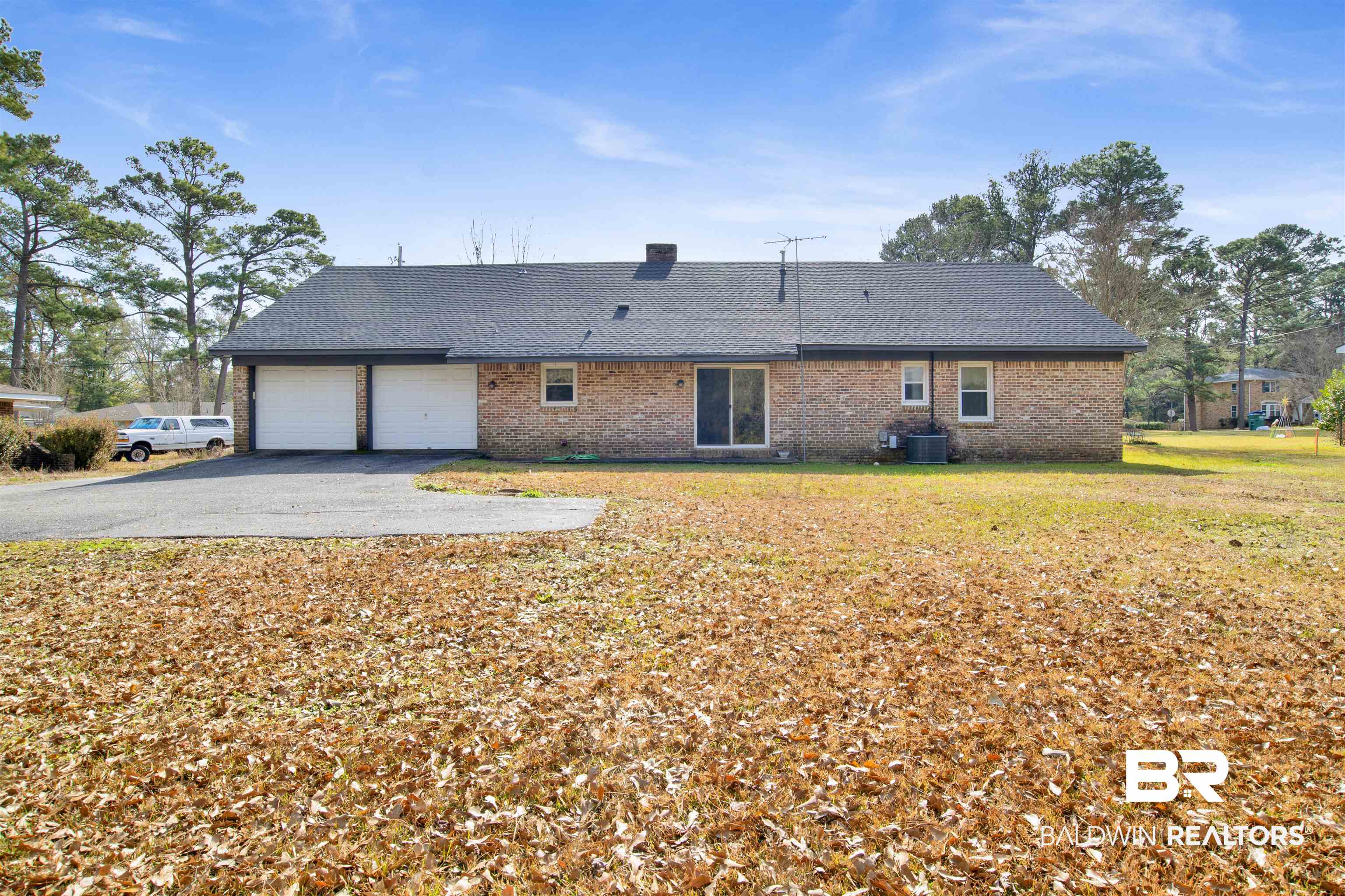 620 Spanish Main Spanish Fort, AL 36527 - Photo 25 of 31 Rear view of house with a yard, a garage, aphalt driveway, central air condition unit, and brick siding