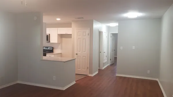 an empty room with wooden floor and white walls