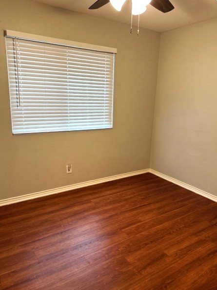 371 Fantail Loop, Unit B Austin, TX 78734 - Photo 6 of 10 Unfurnished room with a ceiling fan and dark wood-style flooring