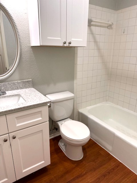 371 Fantail Loop, Unit B Austin, TX 78734 - Photo 8 of 10 Full bath with vanity, dark wood finished floors, a textured wall, and shower / tub combination