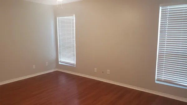 an empty room with wooden floor and a window