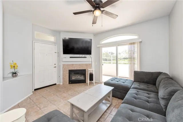 a living room with furniture a flat screen tv and a fireplace