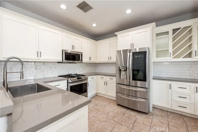 a kitchen with stainless steel appliances granite countertop a refrigerator and a stove top oven