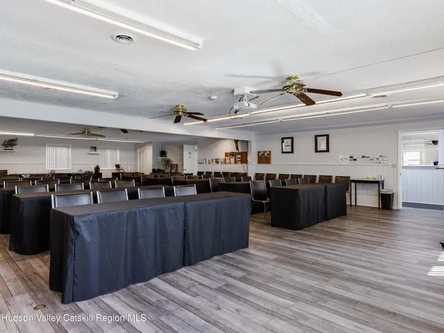 a room with lots of wooden furniture and a view of kitchen