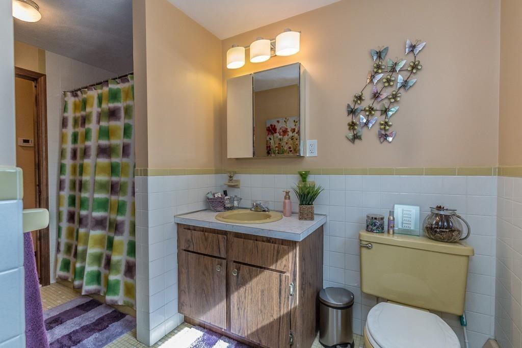 21 Meadowvale Road Burlington, MA 01803 - Photo 16 of 30 a bathroom with a sink a toilet a mirror and shower curtain