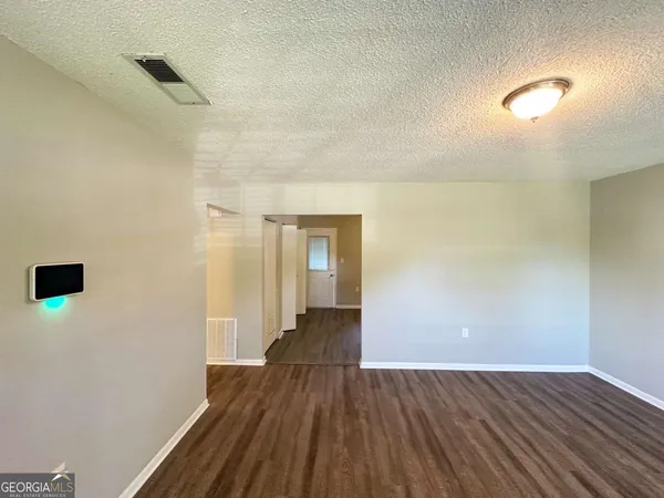 a view of an empty room with wooden floor