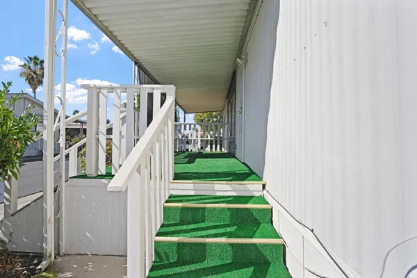 a view of a white house with wooden fence
