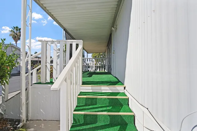 a view of a white house with wooden fence