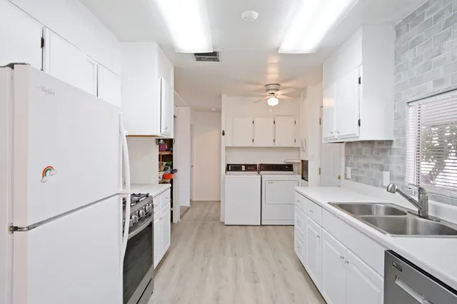 a kitchen with white cabinets sink and white appliances