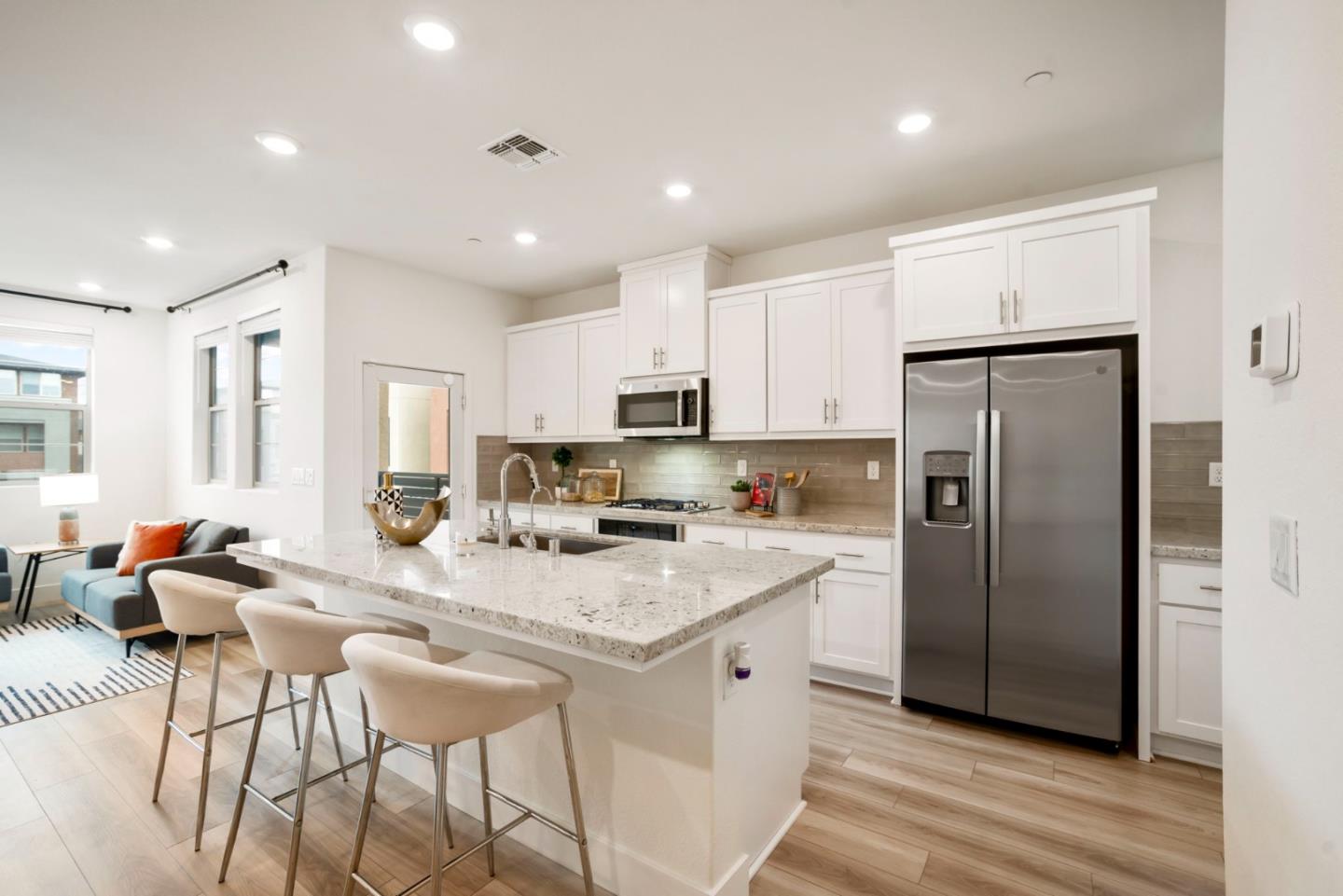 5720 Greige Circle, Unit G Dublin, CA 94568 - Photo 15 of 55 a kitchen with stainless steel appliances granite countertop a refrigerator a sink dishwasher a stove and white cabinets with wooden floor