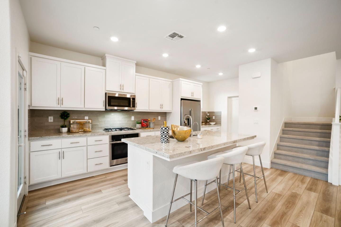 5720 Greige Circle, Unit G Dublin, CA 94568 - Photo 16 of 55 a kitchen with stainless steel appliances kitchen island granite countertop a stove a sink a refrigerator and white cabinets