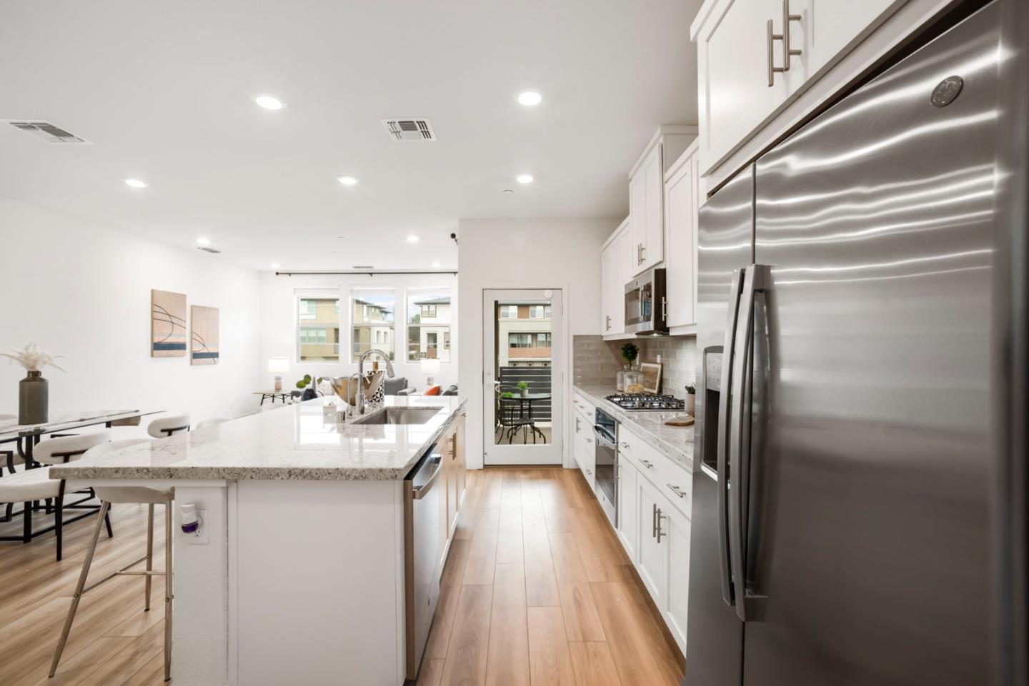 5720 Greige Circle, Unit G Dublin, CA 94568 - Photo 19 of 55 a kitchen with kitchen island a counter top space a sink stainless steel appliances and cabinets