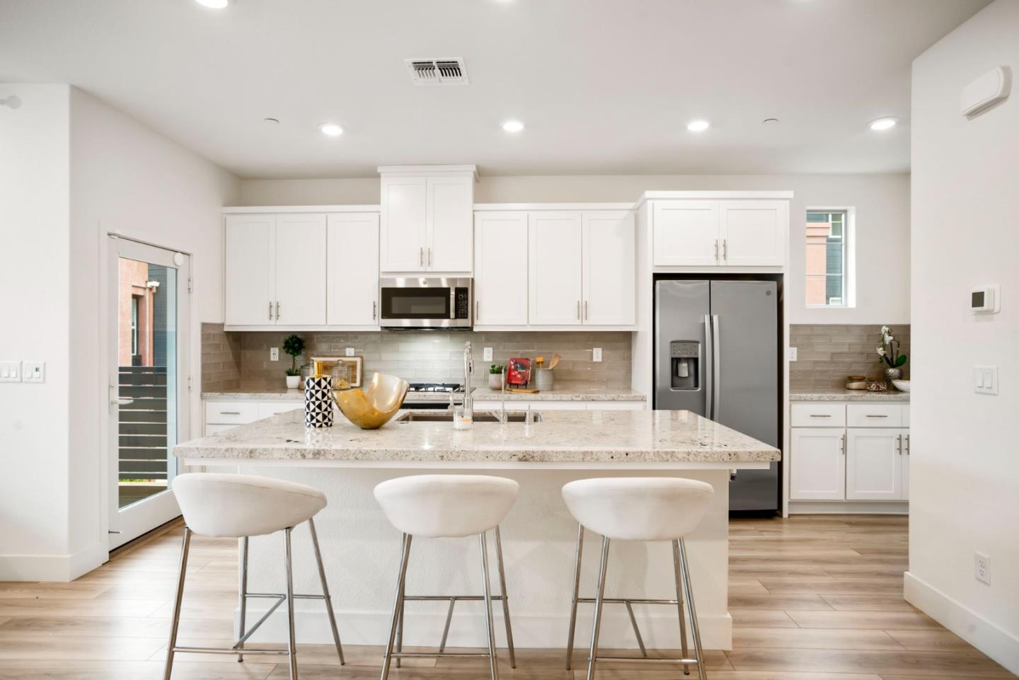 5720 Greige Circle, Unit G Dublin, CA 94568 - Photo 2 of 55 a kitchen with stainless steel appliances kitchen island granite countertop a dining table chairs refrigerator and sink