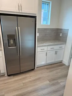 a view of a kitchen with wooden cabinet and a refrigerator