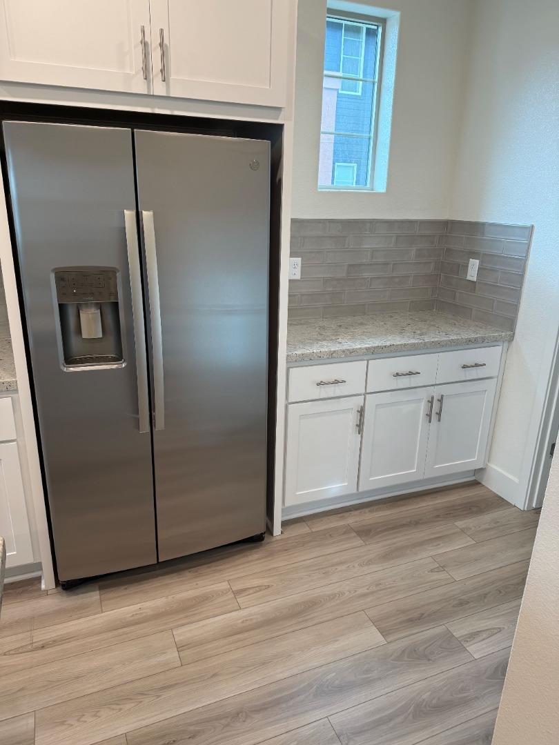 5720 Greige Circle, Unit G Dublin, CA 94568 - Photo 6 of 13 a view of a kitchen with wooden cabinet and a refrigerator