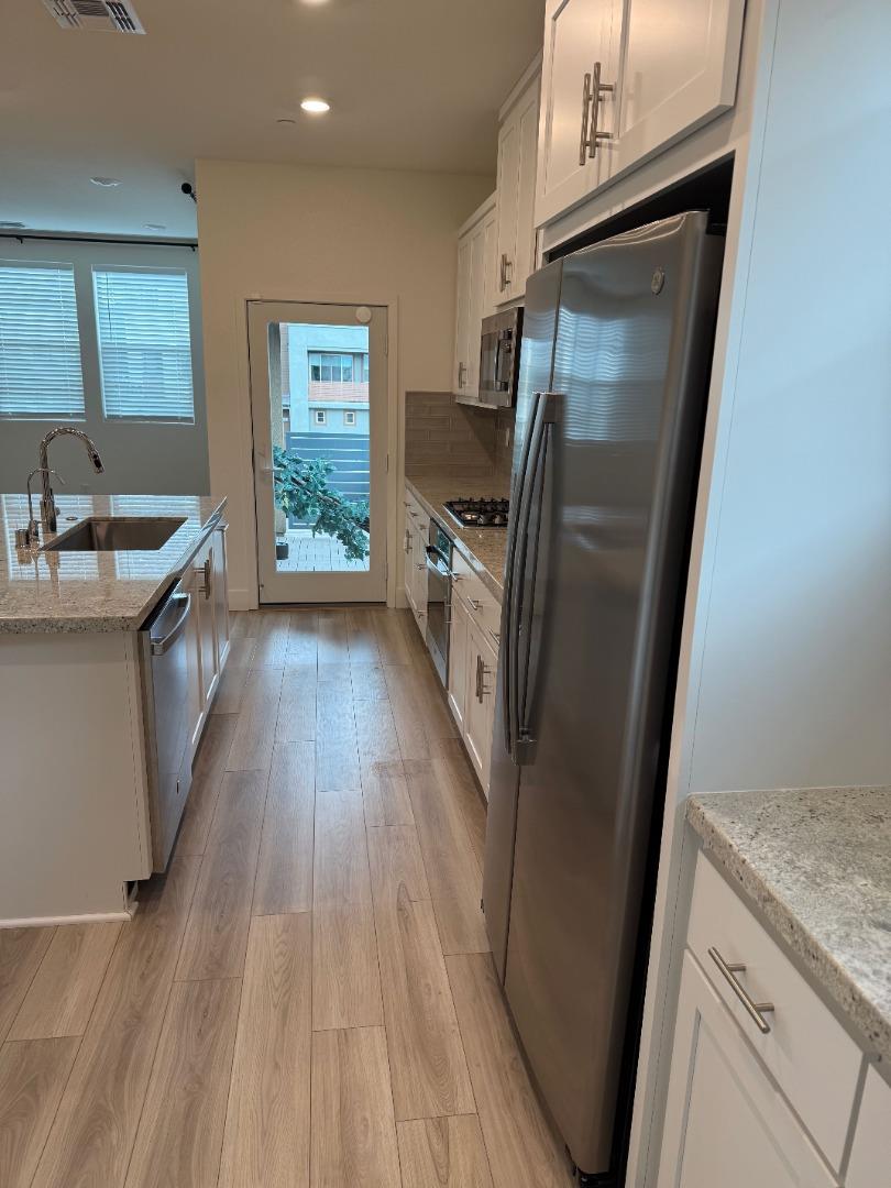 5720 Greige Circle, Unit G Dublin, CA 94568 - Photo 7 of 13 a kitchen with sink a refrigerator and wooden floor