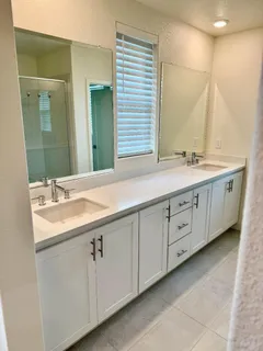 a bathroom with a double vanity sink and mirror
