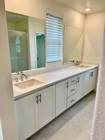 a bathroom with a double vanity sink and mirror