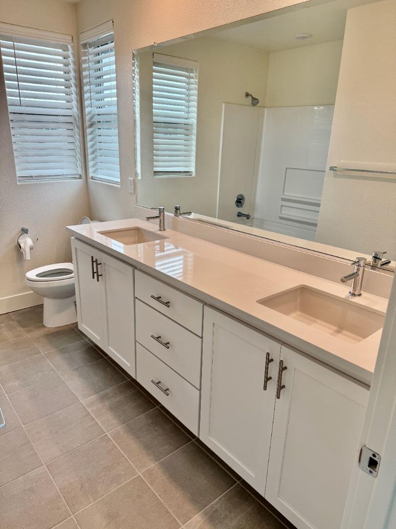 5720 Greige Circle, Unit G Dublin, CA 94568 - Photo 10 of 13 a bathroom with a double vanity sink a toilet and a tub