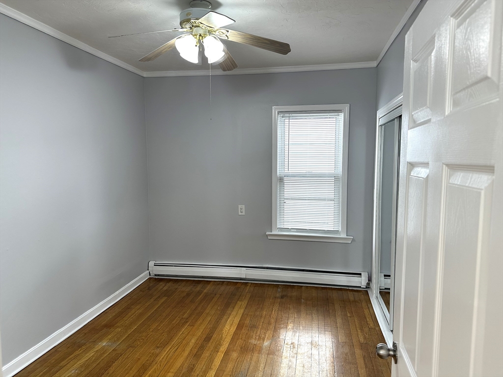 396 Durfee Street, Unit 1 Fall River, MA 02720 - Photo 3 of 13 a view of an empty room with wooden floor and a window