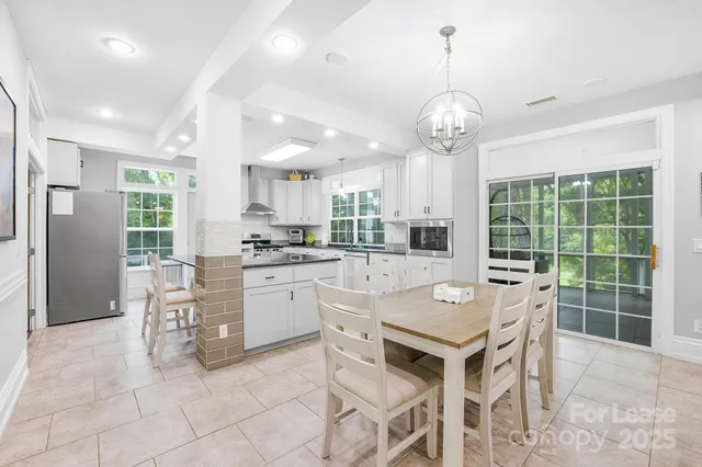 a kitchen with stainless steel appliances granite countertop a stove top oven a refrigerator a sink and a refrigerator