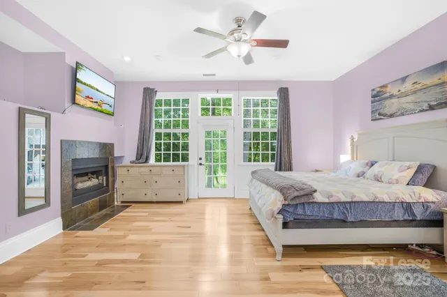 a bedroom with a bed flat screen tv and a fireplace