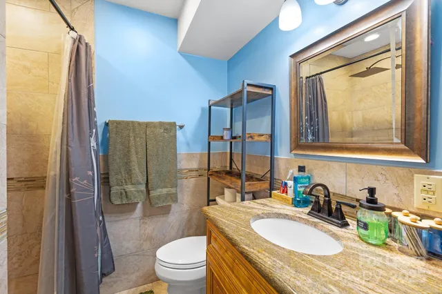 a bathroom with a granite countertop sink toilet and shower