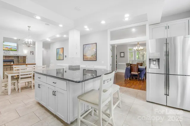 a kitchen with stainless steel appliances kitchen island granite countertop a refrigerator and a stove top oven