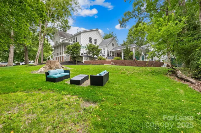 a front view of a house with garden and trees