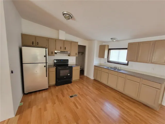 a kitchen with granite countertop a refrigerator and a sink
