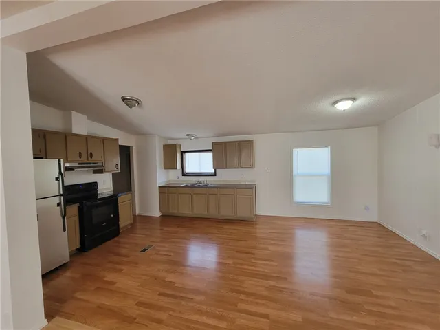 a kitchen with a refrigerator and a stove top oven