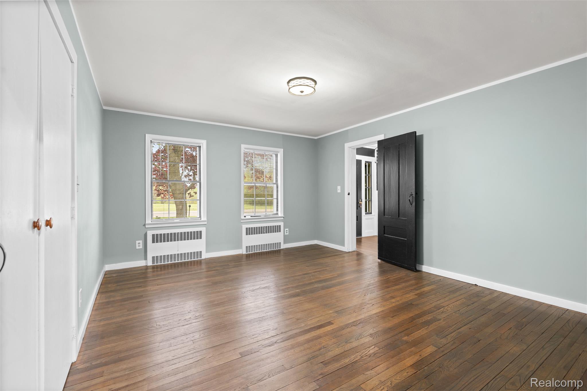 1775 Imlay City Road Lapeer, MI 48446 - Photo 16 of 60 Spare room with dark wood-type flooring, ornamental molding, and radiator