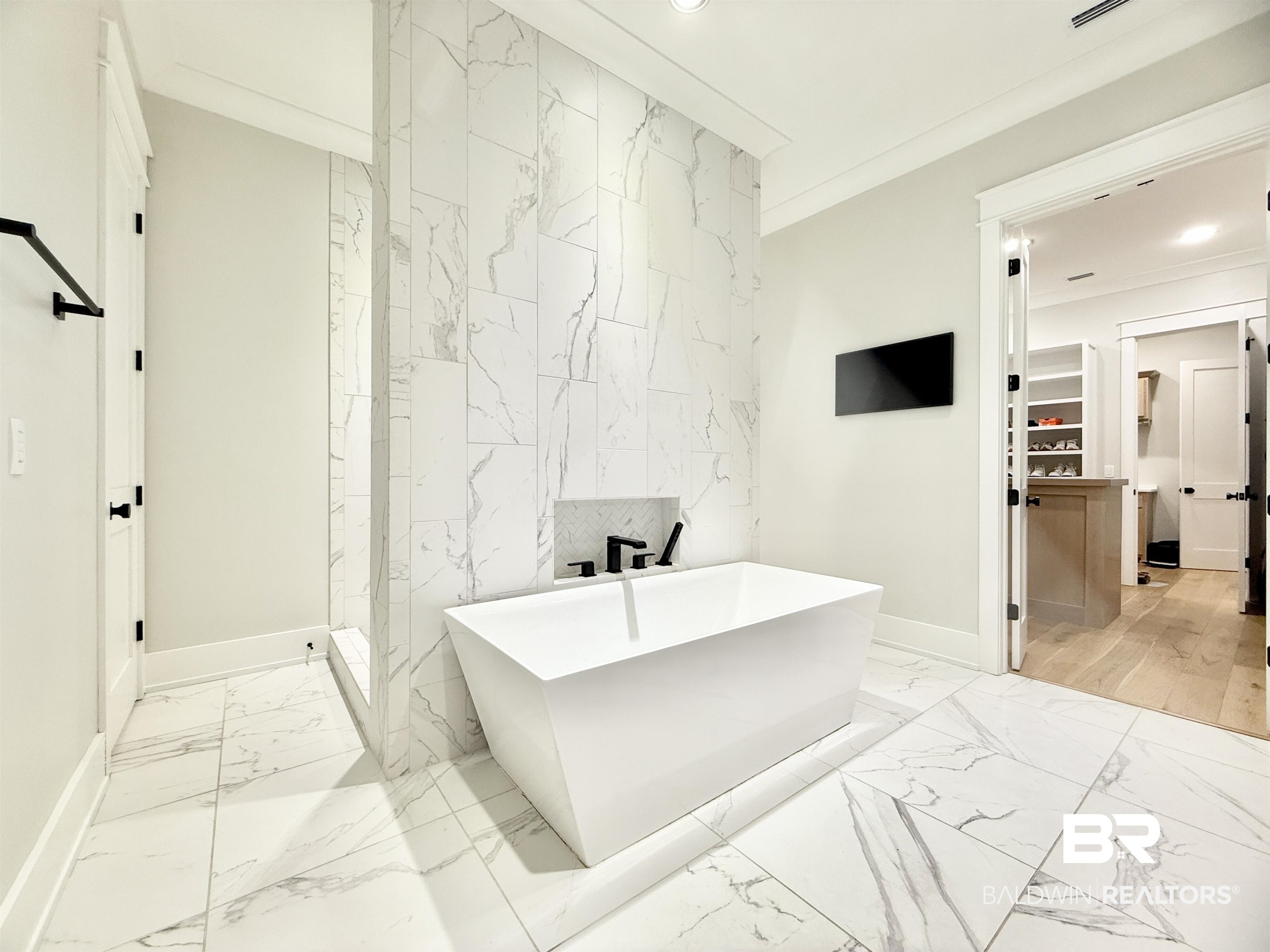 21767 Gallery Boulevard Fairhope, AL 36532 - Photo 32 of 74 Full bathroom featuring marble look tile flooring, a soaking tub, a walk in closet, recessed lighting, and tile walls