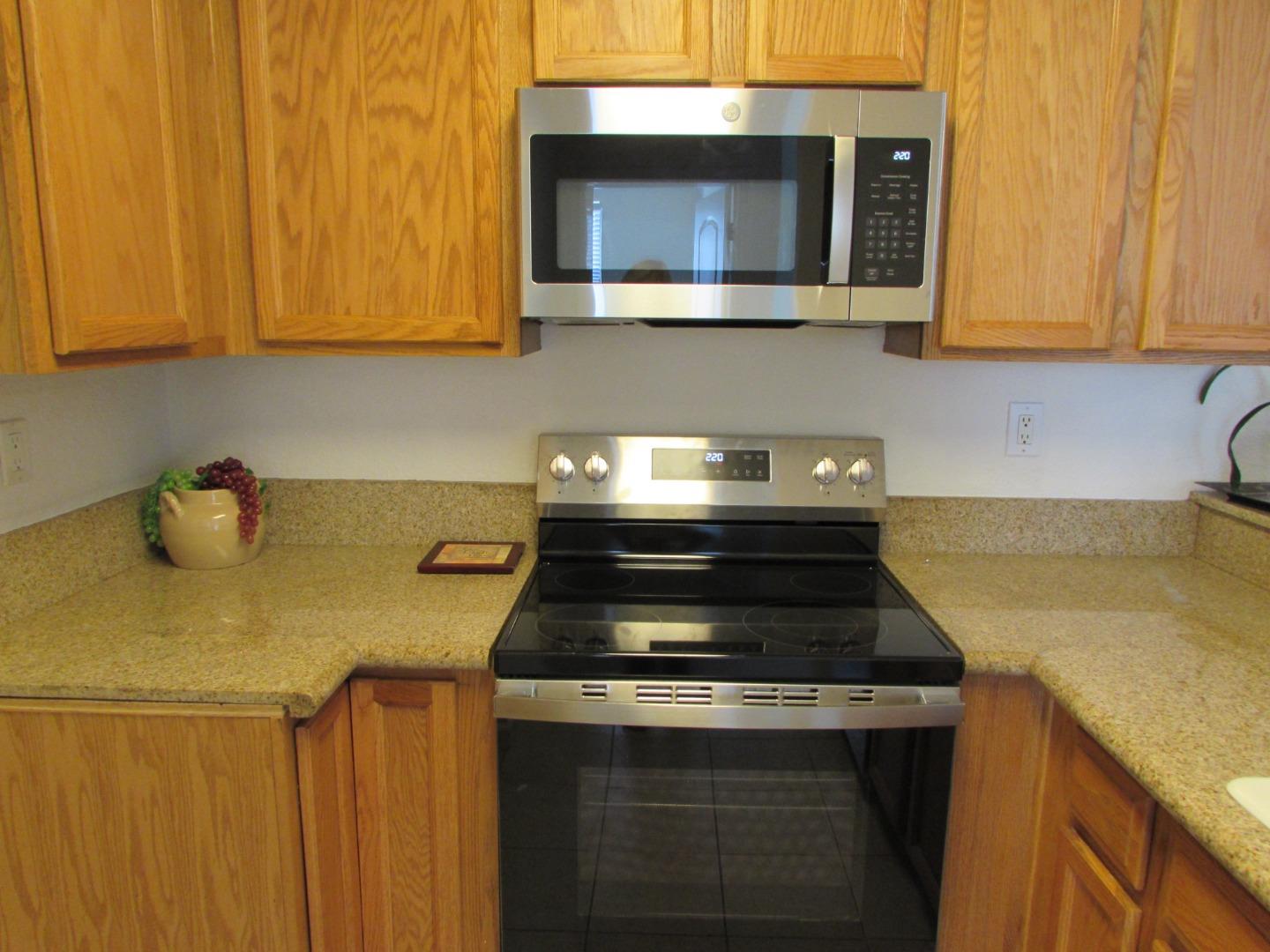 409 Tyler Place, Unit B Salinas, CA 93906 - Photo 3 of 25 a kitchen with stainless steel appliances granite countertop a stove a microwave and cabinets