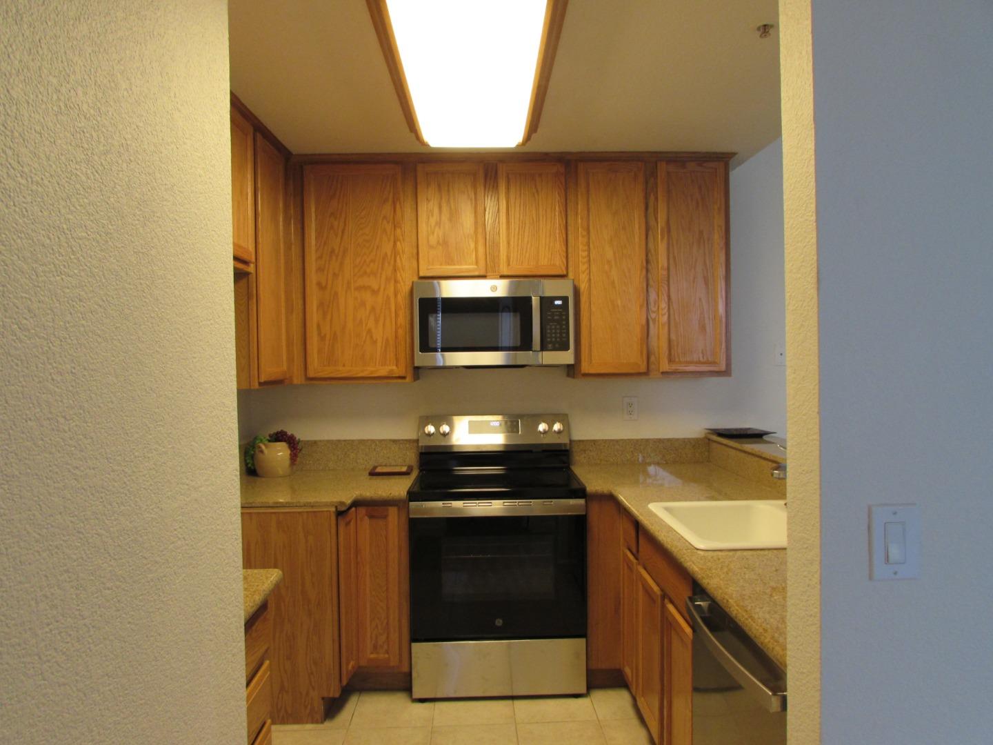 409 Tyler Place, Unit B Salinas, CA 93906 - Photo 4 of 25 a kitchen with a sink and a stove top oven