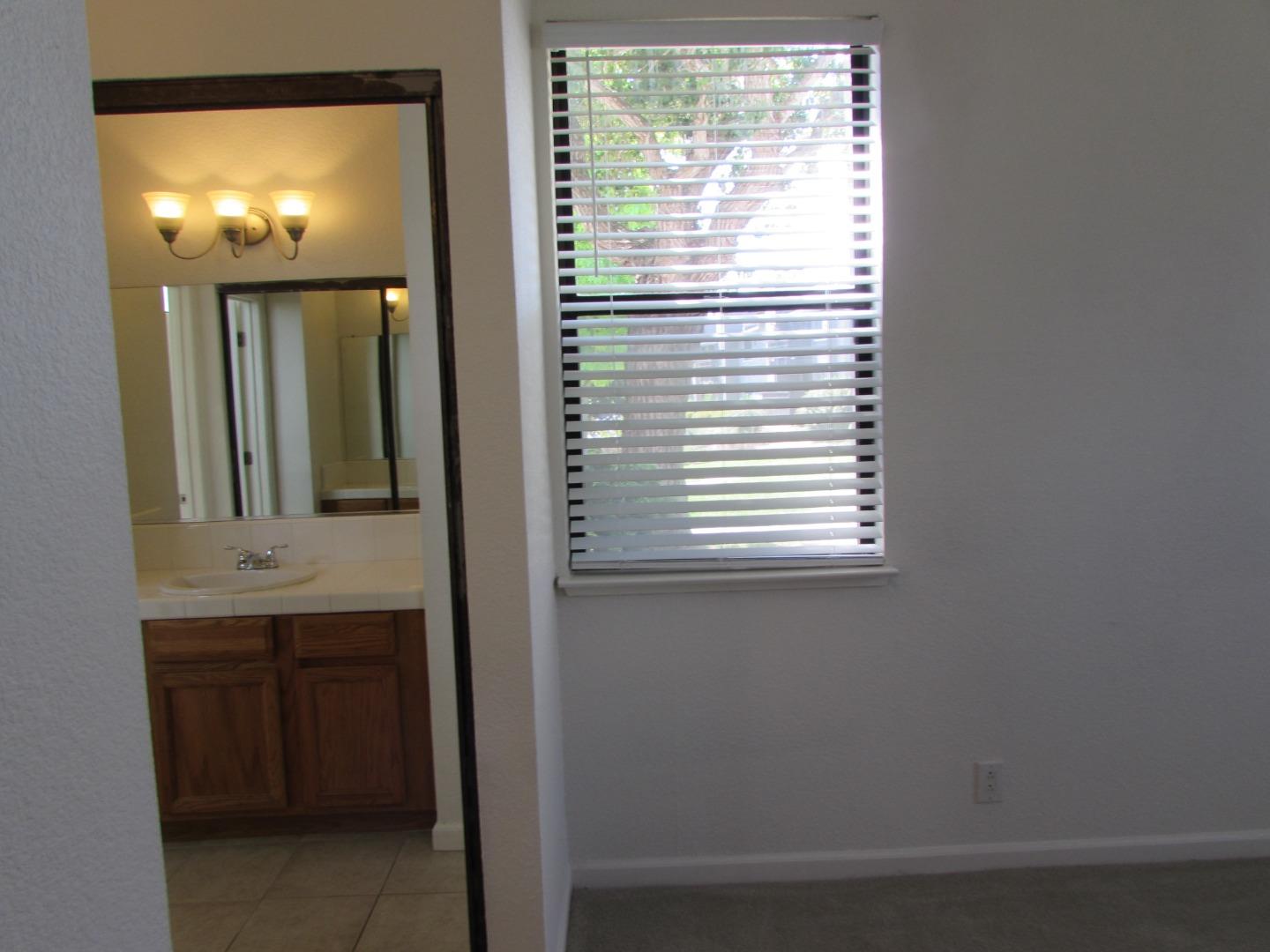 409 Tyler Place, Unit B Salinas, CA 93906 - Photo 10 of 25 a bathroom with a sink a mirror and next to a window