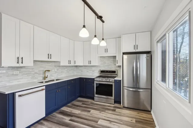 a kitchen with stainless steel appliances granite countertop a refrigerator sink and stove