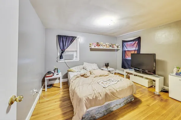 a bed room with a bed a television and a desk