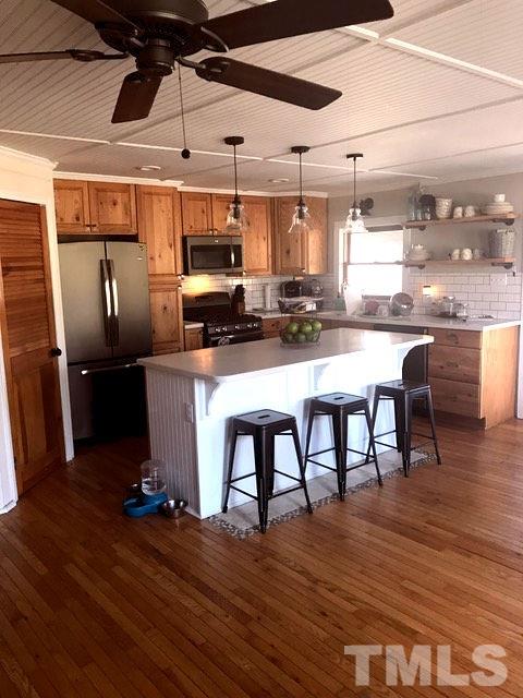 5349 Range Road Rougemont, NC 27572 - Photo 5 of 19 a kitchen with stainless steel appliances a dining table chairs stove and refrigerator