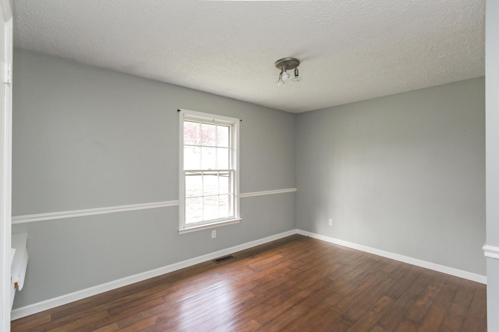 580 Murrell Road Dickson, TN 37055 - Photo 22 of 30 an empty room with wooden floor and windows