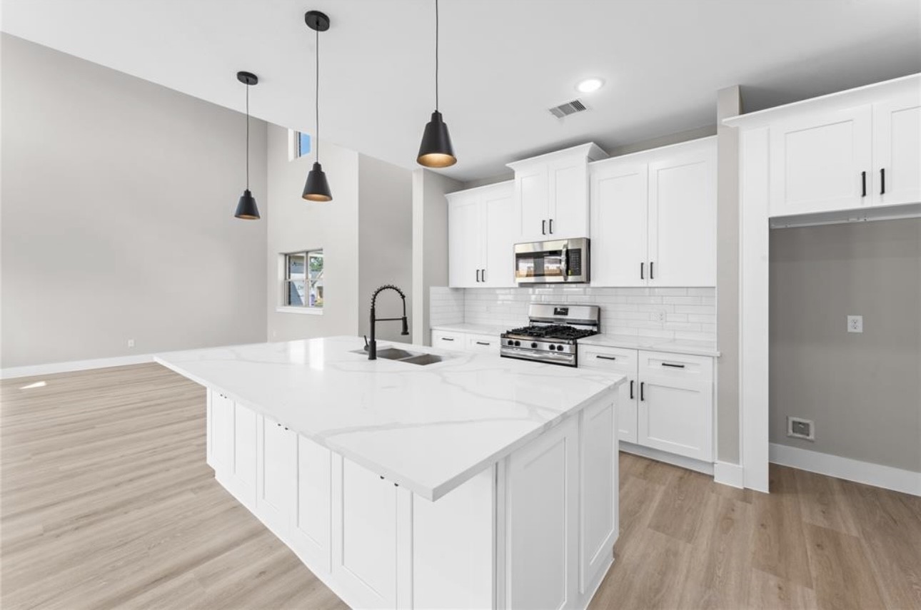 2614 Martinas Ct Spring Spring, TX 77388 - Photo 6 of 15 a kitchen with stainless steel appliances a stove a sink a refrigerator a center island and cabinets