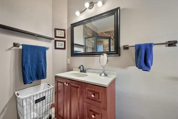 a bathroom with a sink vanity and mirror