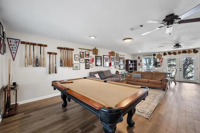 a living room with furniture pool table and a flat screen tv