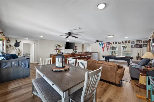 a kitchen with stainless steel appliances granite countertop a dining table and chairs with wooden floor