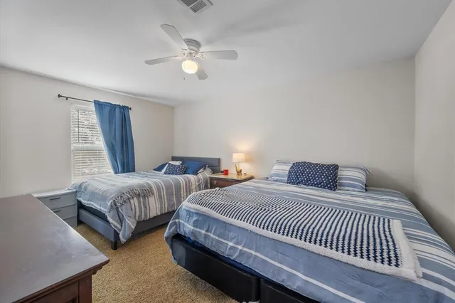 a bedroom with two beds and a chandelier