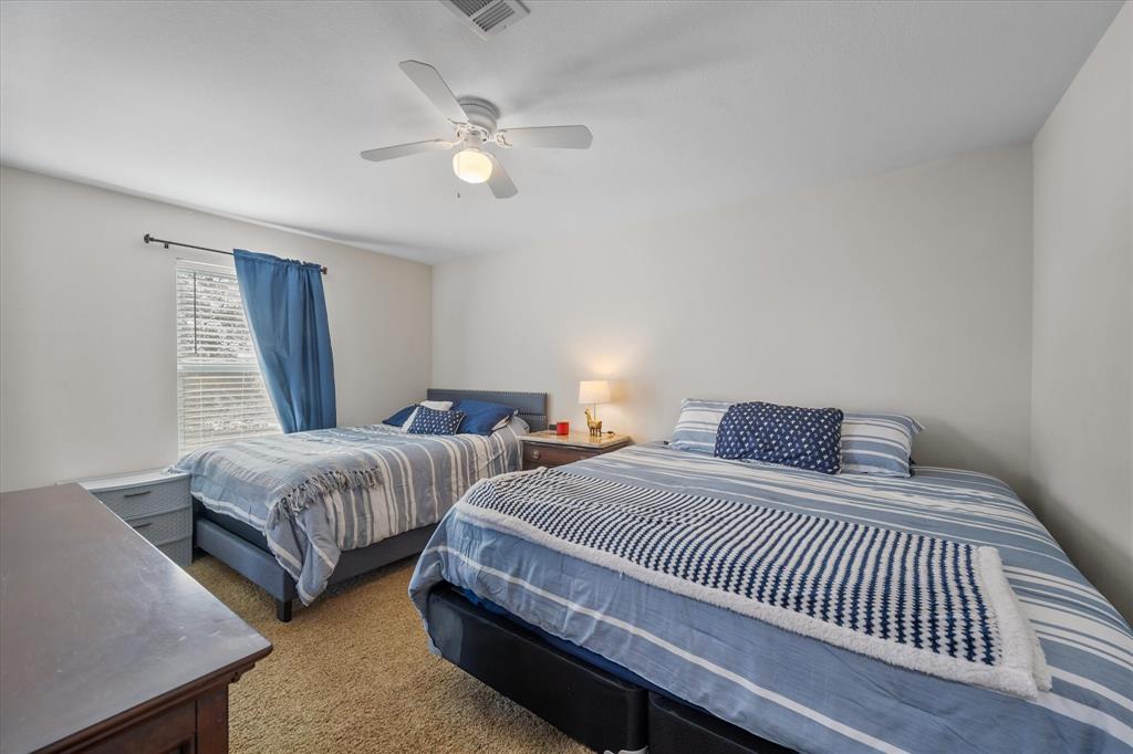 226 Palisade Loop Mabank, TX 75156 - Photo 27 of 40 a bedroom with two beds and a chandelier