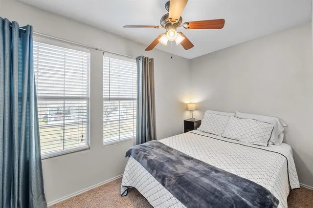 a bedroom with a large bed and a chandelier