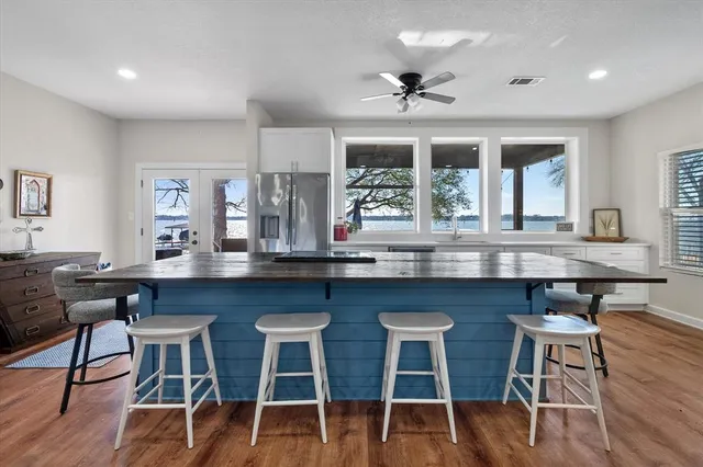 a kitchen with granite countertop a table chairs stove and wooden floor